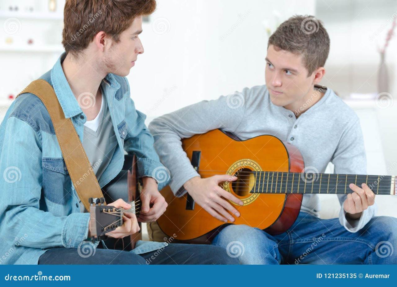 Male Friends Playing Guitar Home Together Stock Photo 2100842875 ...